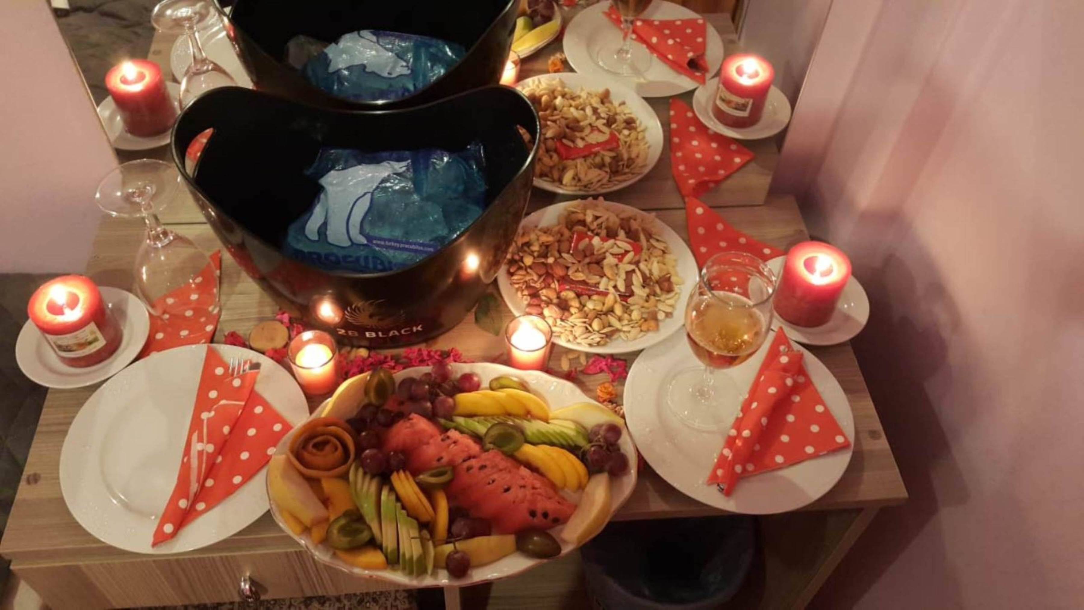 Ein Tisch, gedeckt für eine Mahlzeit, mit Tellern, Gläsern und Kerzen.