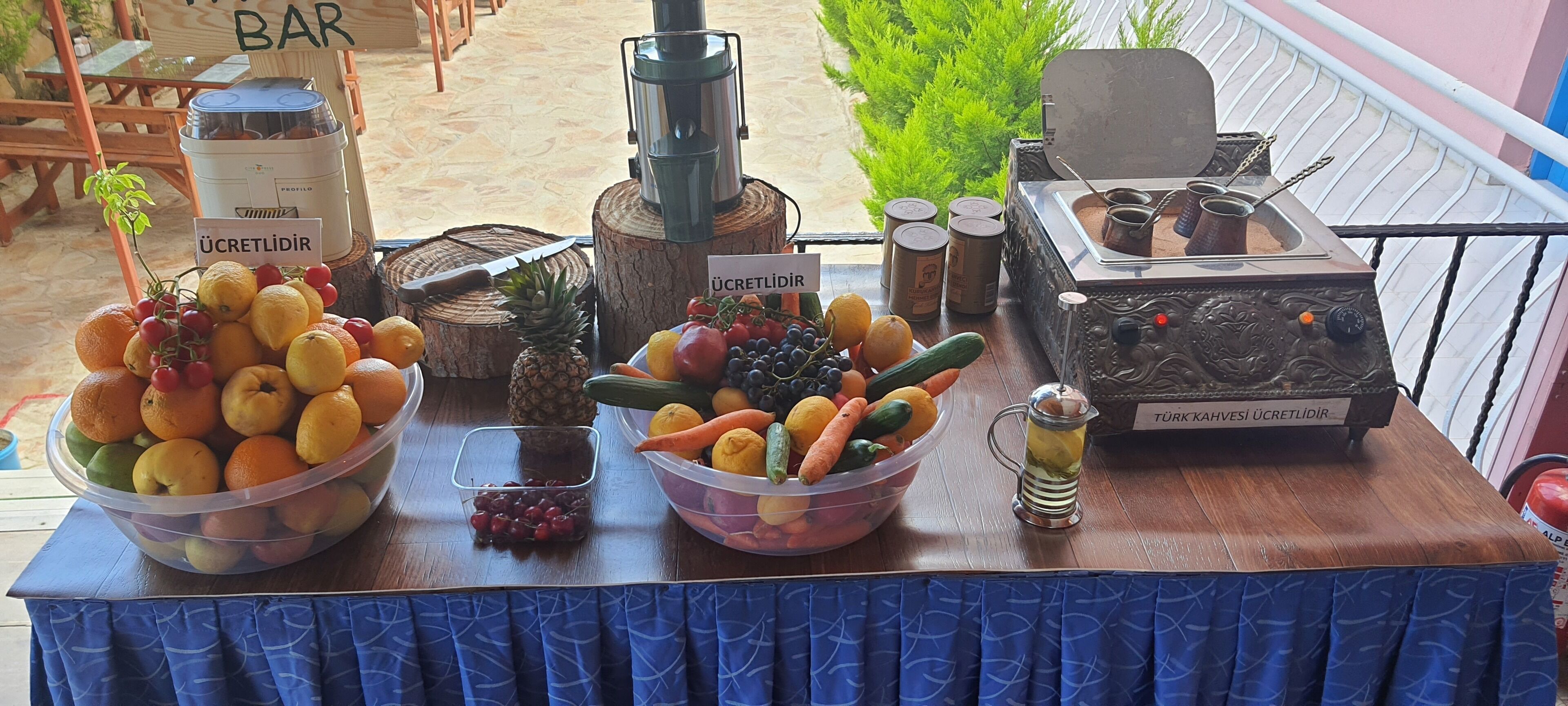 A fruit display with various fruits and a Turkish coffee machine.