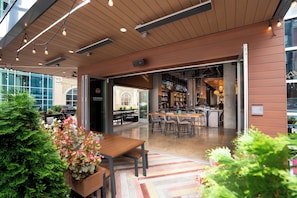 Un espace de restauration intérieur avec des tables et des chaises en bois, un bar et une vue sur la rue.