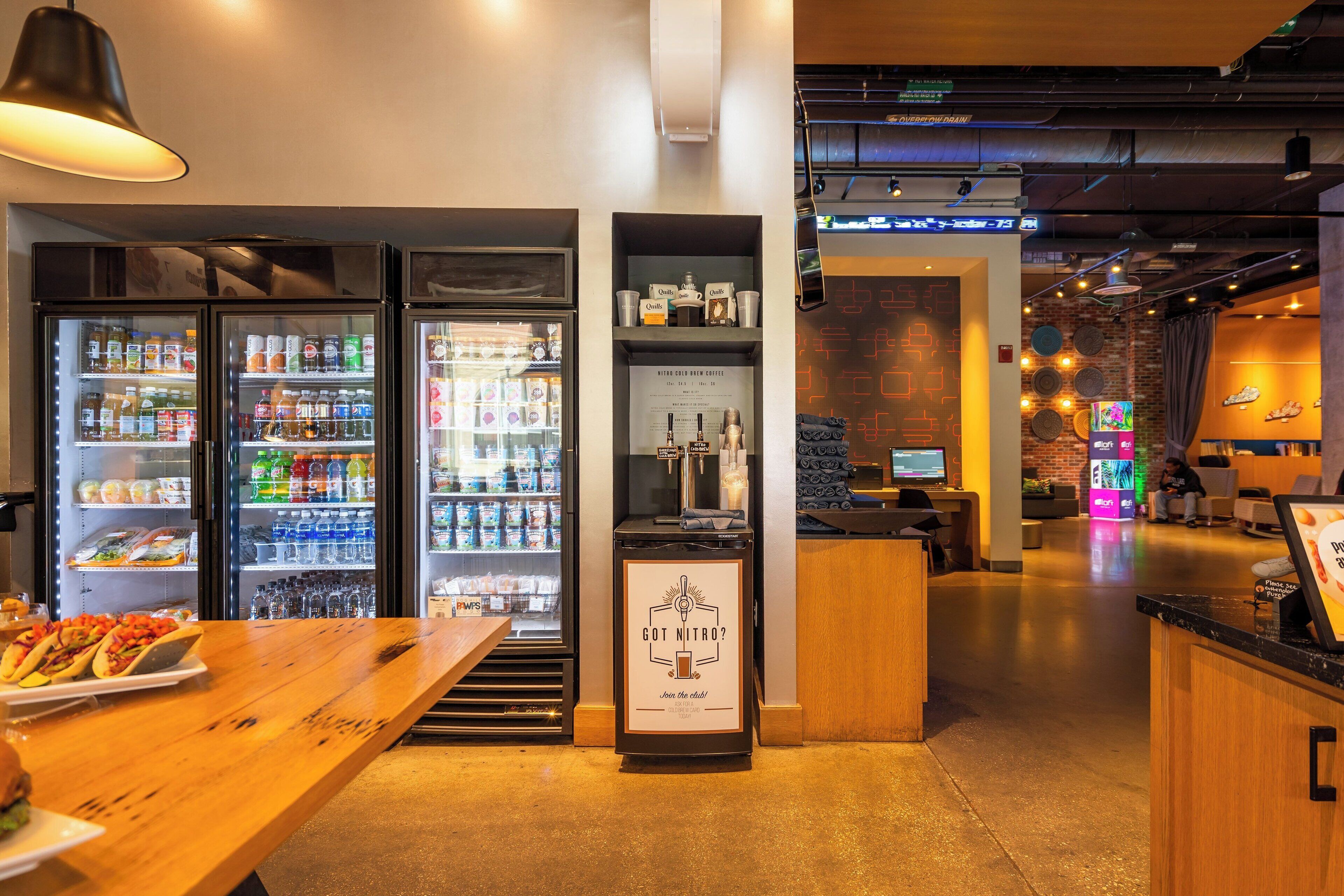 A modern coffee shop interior with a wooden counter, a coffee machine, and a menu board.