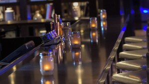 A bar area with a long counter, glasses, and bottles. - Renaissance Albany Hotel (Albany)