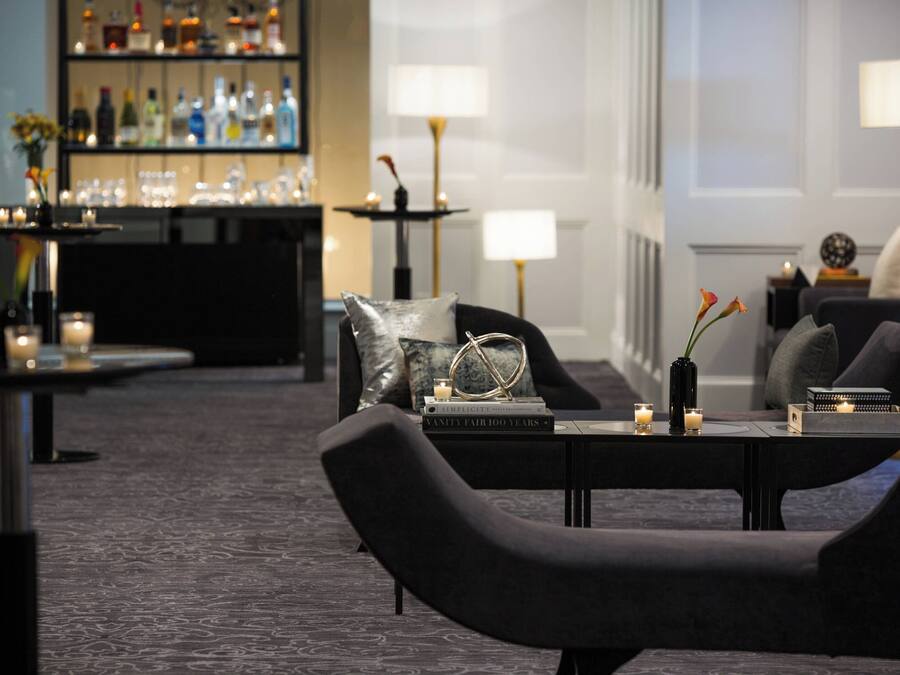 A modern lounge area with a bar, seating, and ambient lighting.