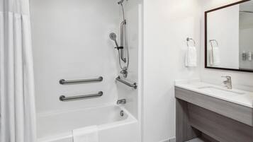 Un baño moderno con bañera, ducha y tocador.