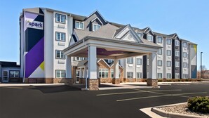 A hotel with a covered entrance, multiple floors, and a parking lot. - Spark by Hilton Rochester South (Rochester)
