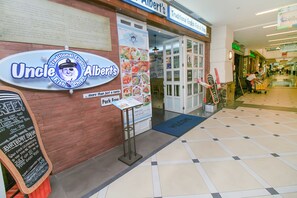 A storefront with a sign reading "Uncle Albert's Traditional English Fish & Chips" and a chalkboard sign advertising daily specials. - Home Suites by Marina (George Town)