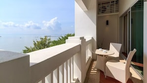 A balcony with a view of the sea, a table with chairs, and a ceiling fan. - Home Suites by Marina (George Town)