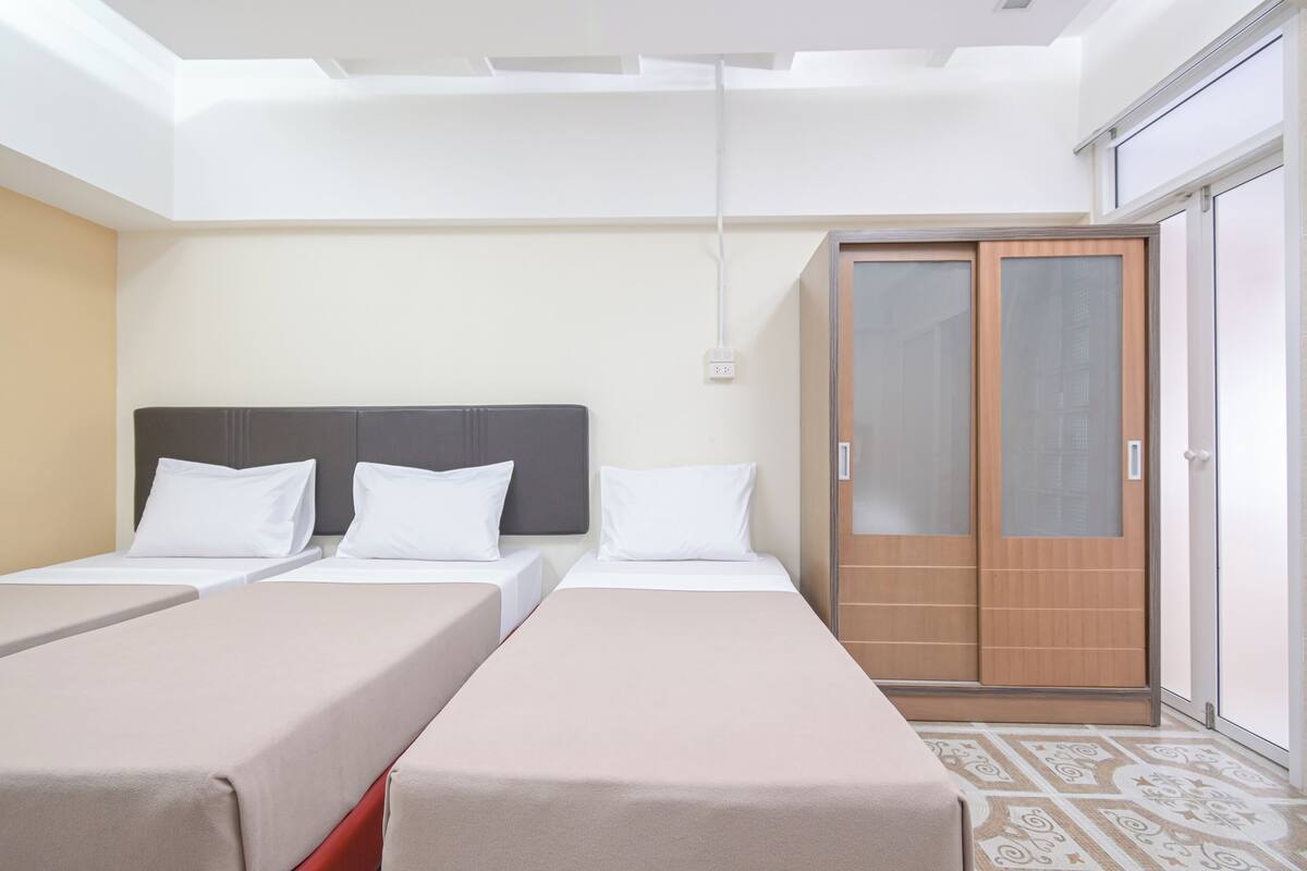 A hotel room with two single beds, a wardrobe, and a skylight.