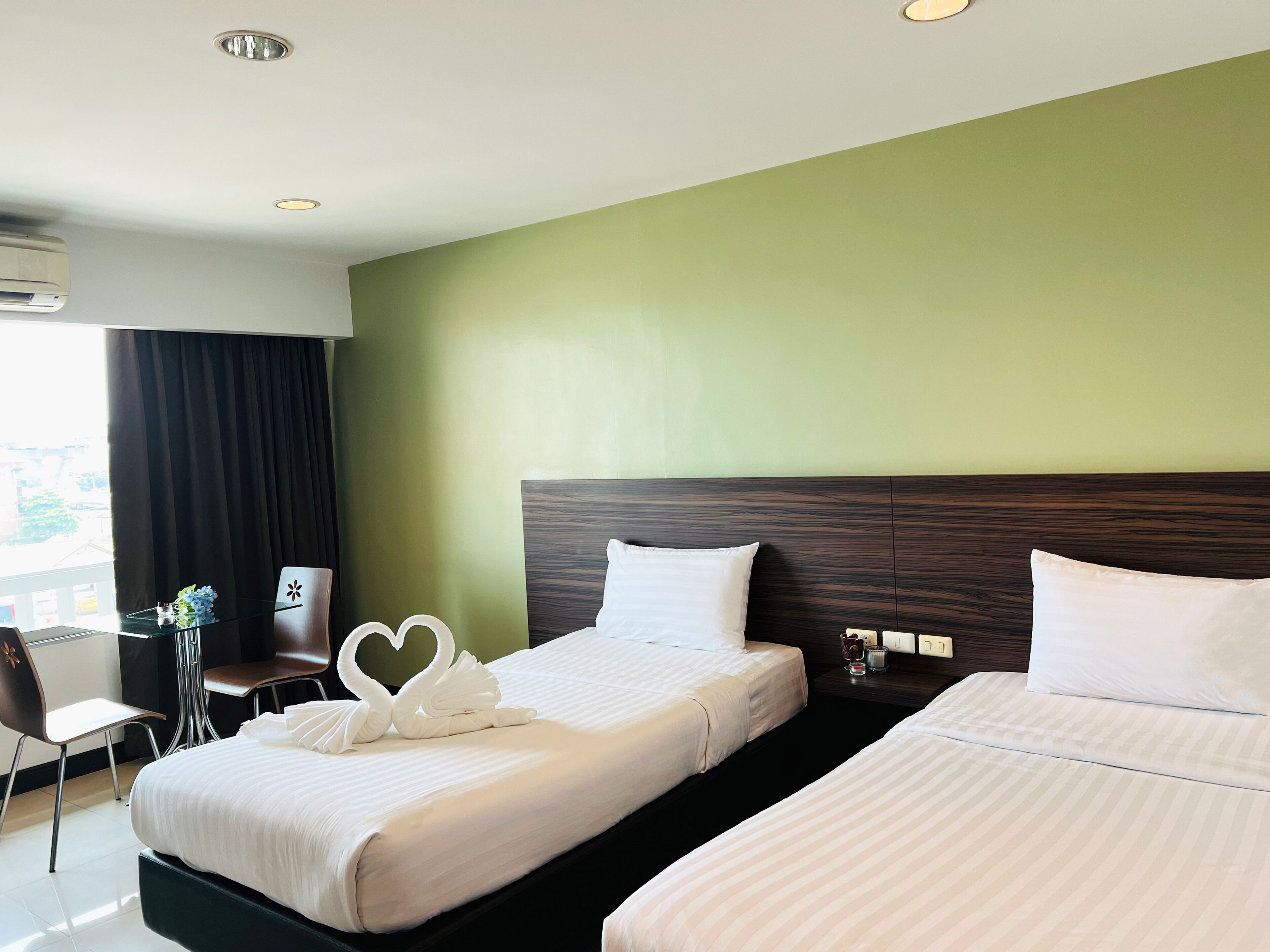 Habitación de hotel con dos camas, un escritorio y una silla.