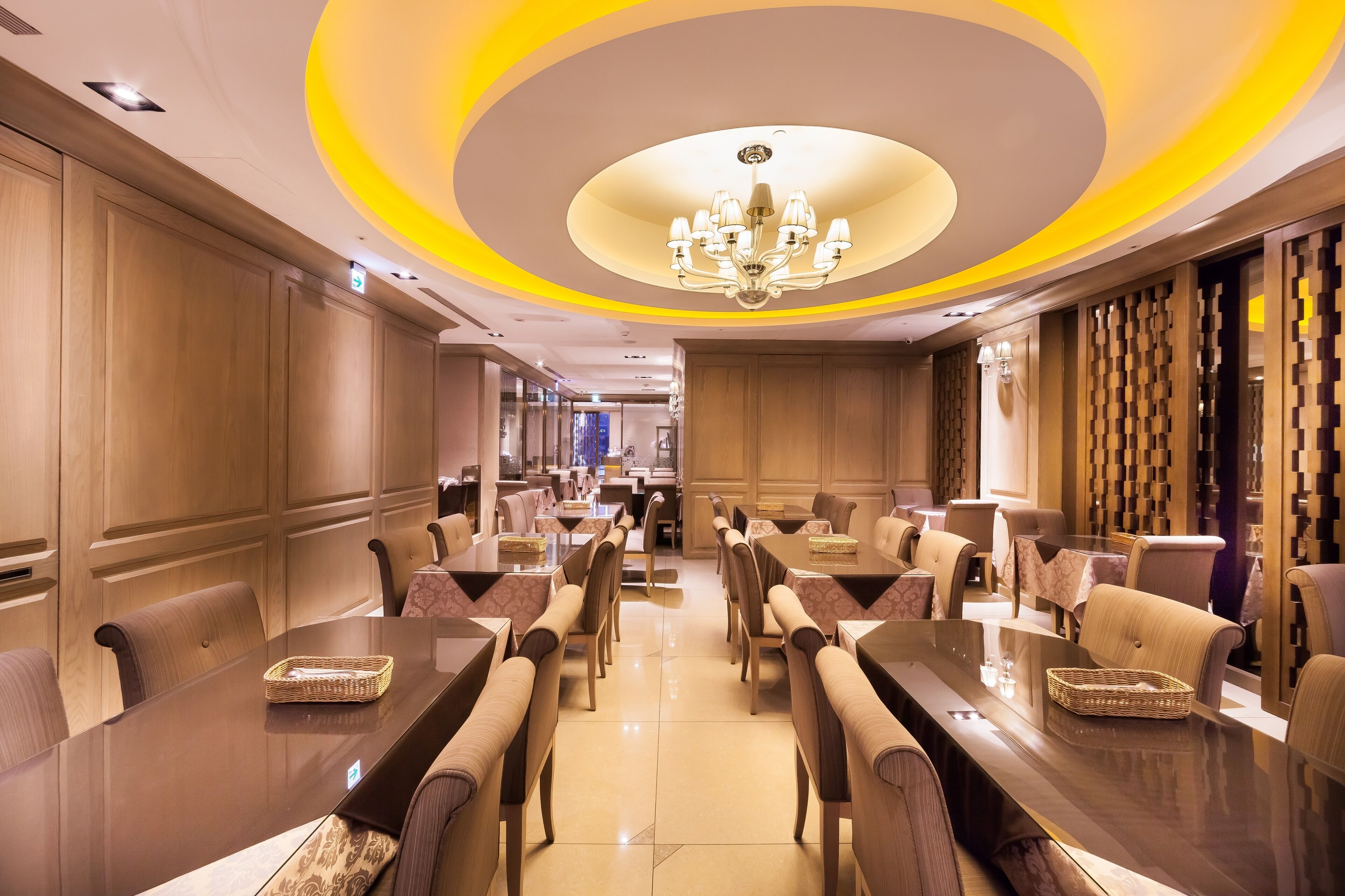 A spacious conference room with a long table, comfortable chairs, and a chandelier.