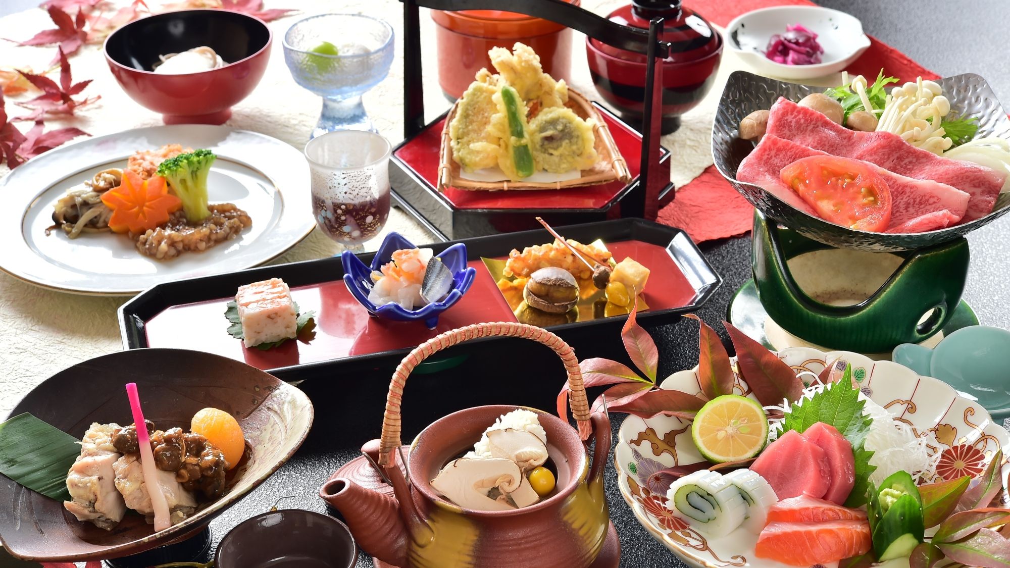 A variety of Japanese dishes arranged on a table with multiple serving dishes and a teapot.
