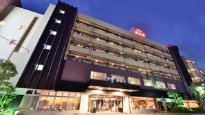 A multi-story hotel with a modern facade, illuminated windows, and a visible entrance. - Hotel Marusansou (Chikuma)