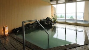 Un bassin de spa doté d’une paroi en bois et de grandes fenêtres.