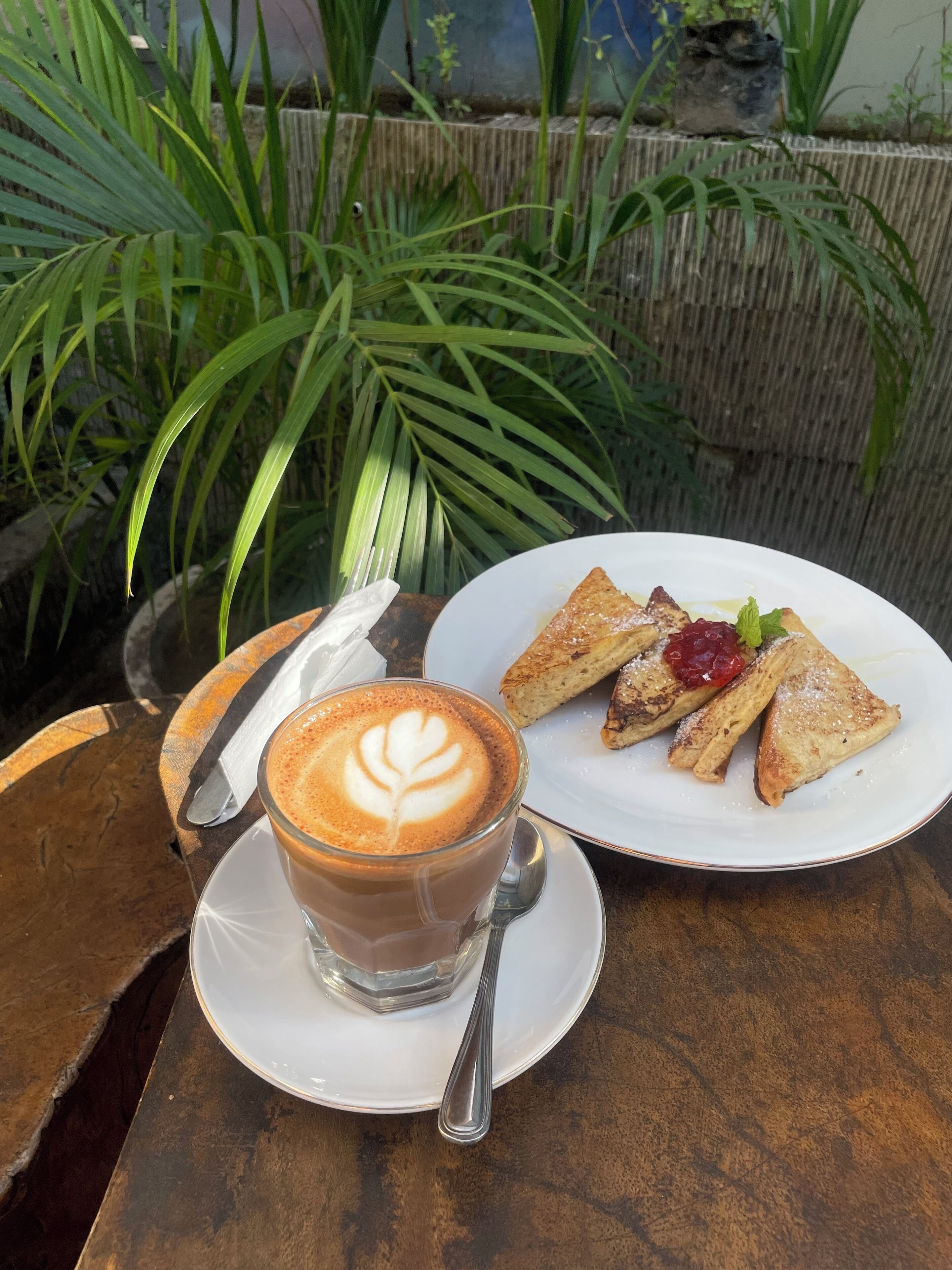 A table with a cup of coffee and a plate of pastries.