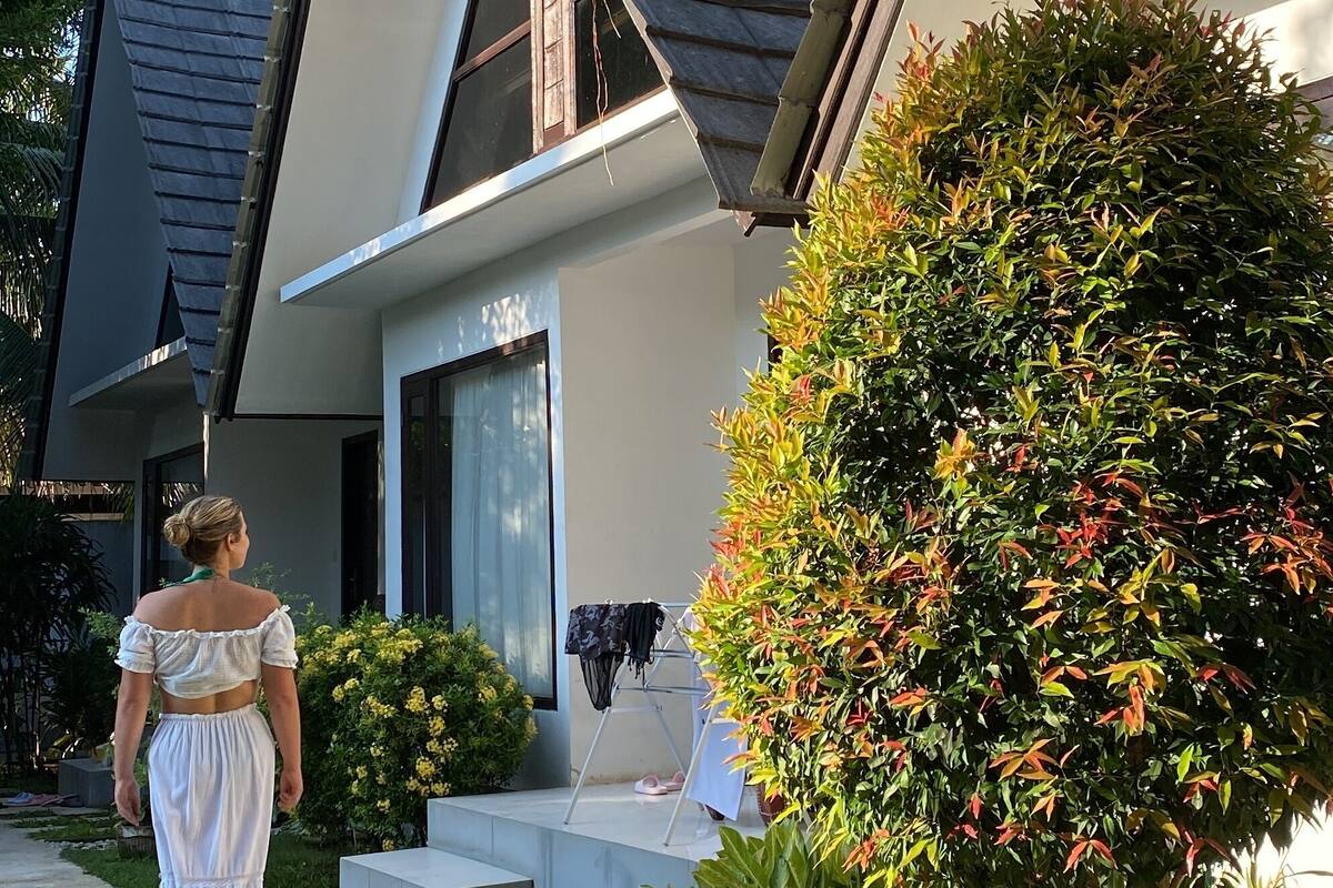 A residential house with a sloped roof, a front porch, and a well-maintained garden.