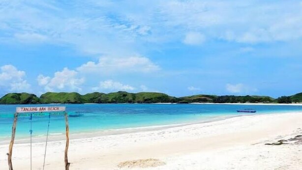 Una playa con un cartel que dice "Tanjung Aan Beach".