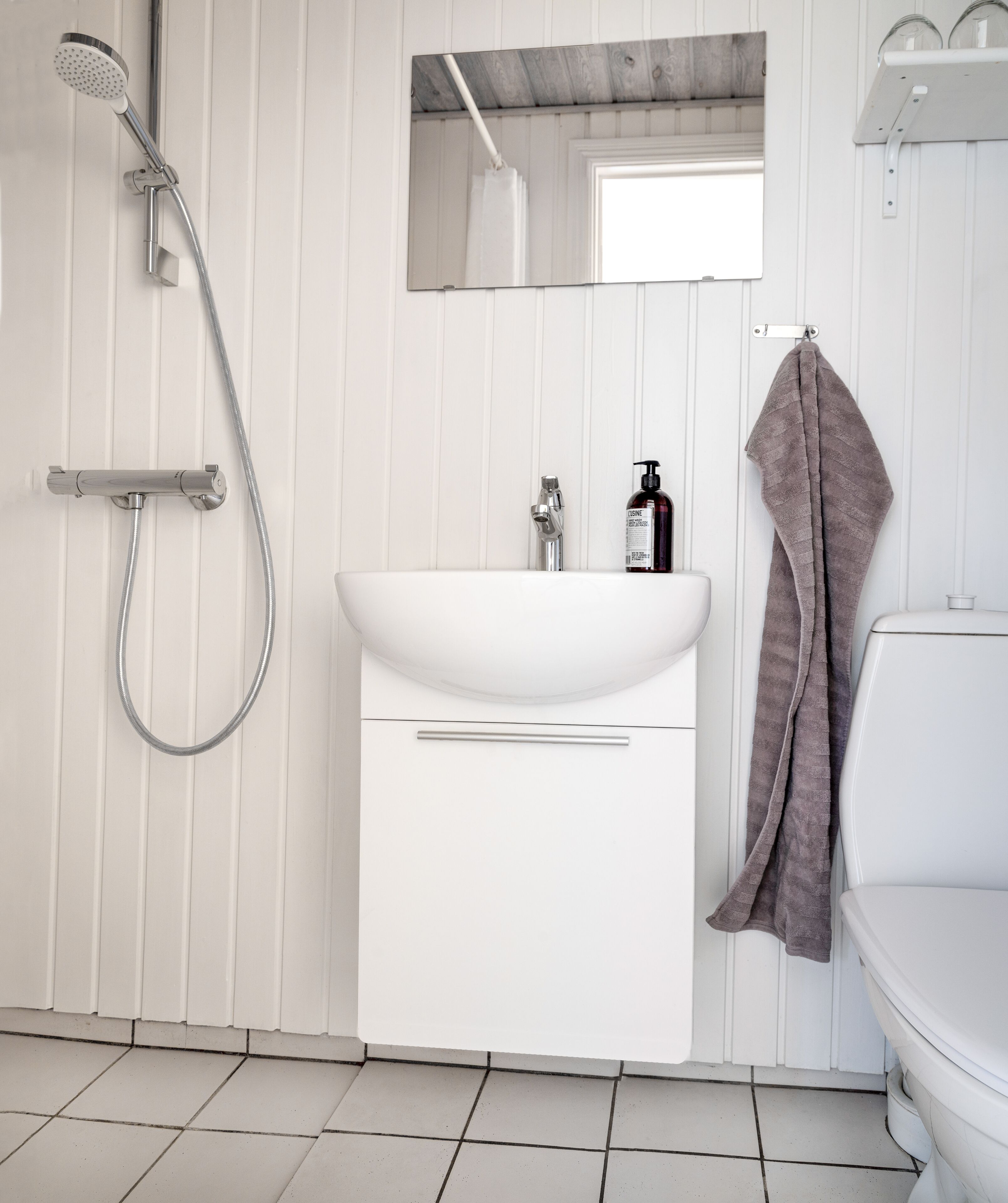 Un baño moderno con ducha, lavamanos e inodoro.