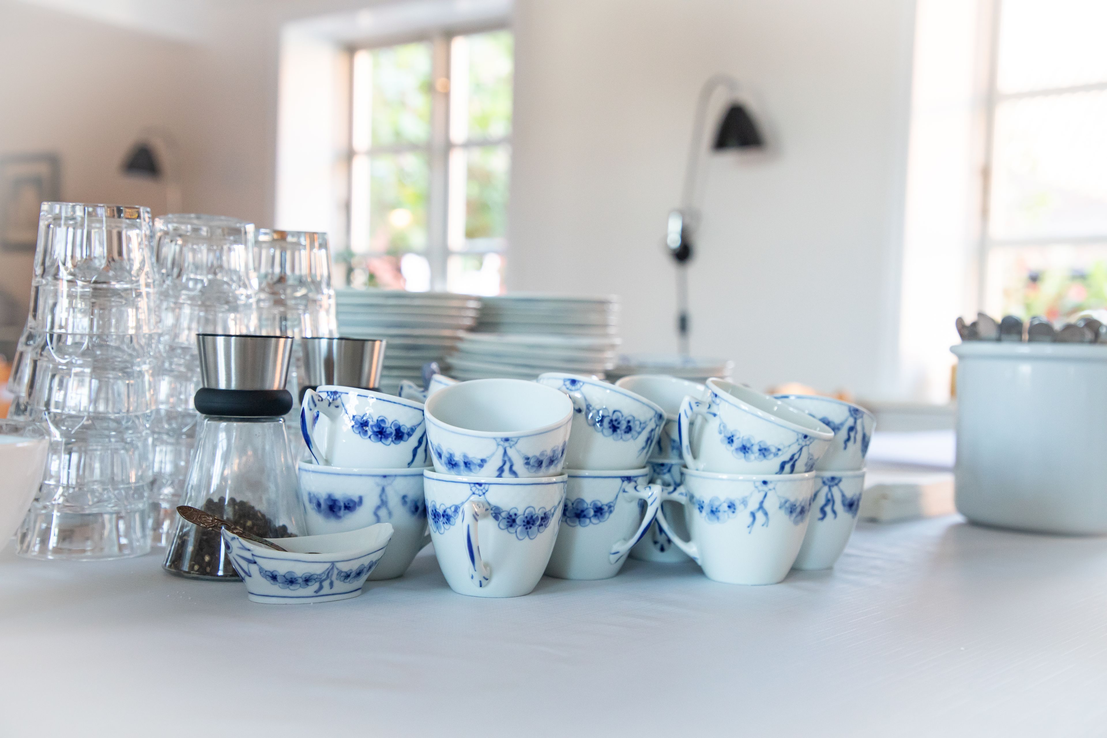 A table with various glassware and ceramic dishes, including cups and bowls, arranged neatly.