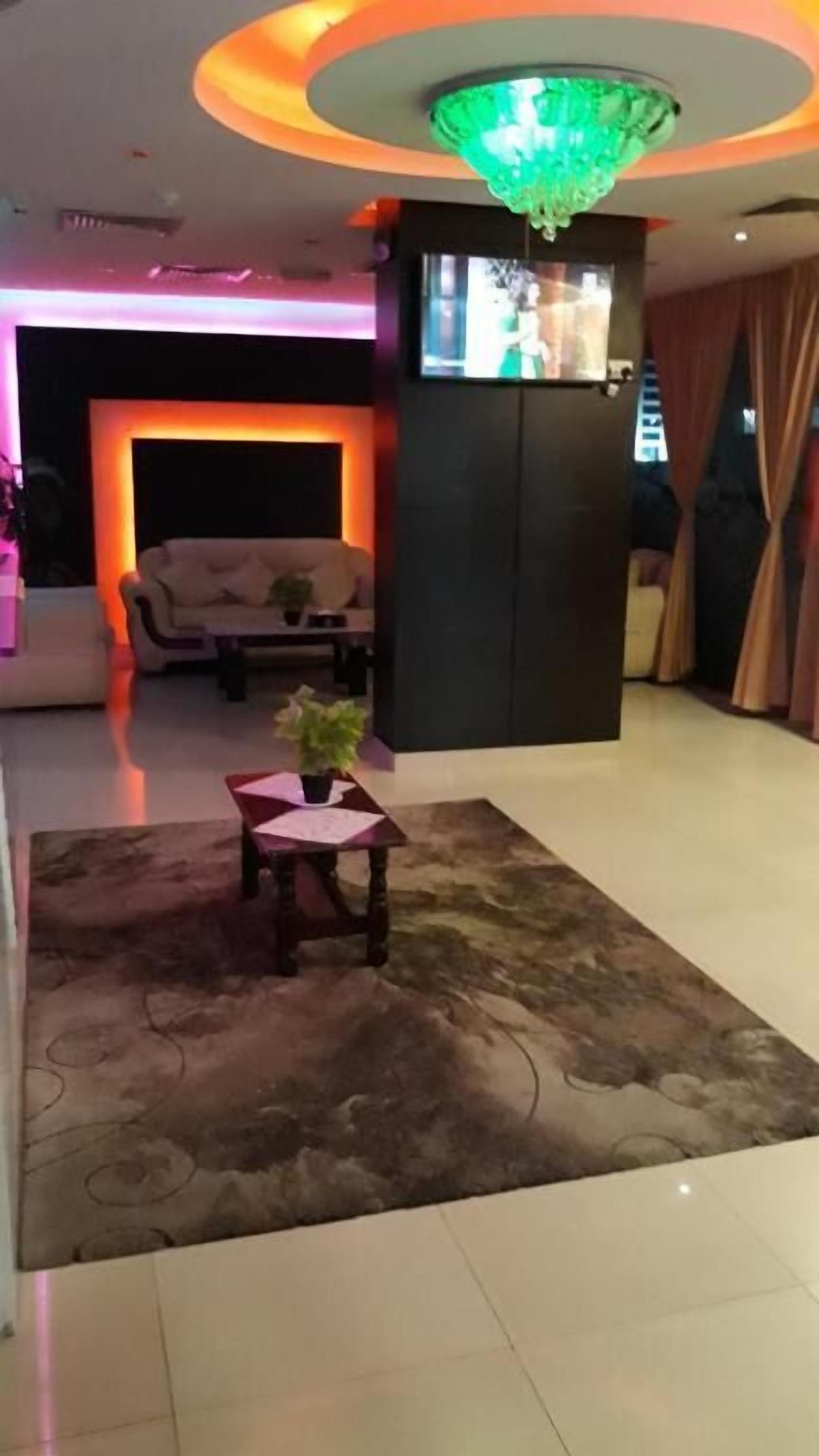Een moderne woonkamer met een flatscreen televisie, een bank, een salontafel en een decoratief vloerkleed.