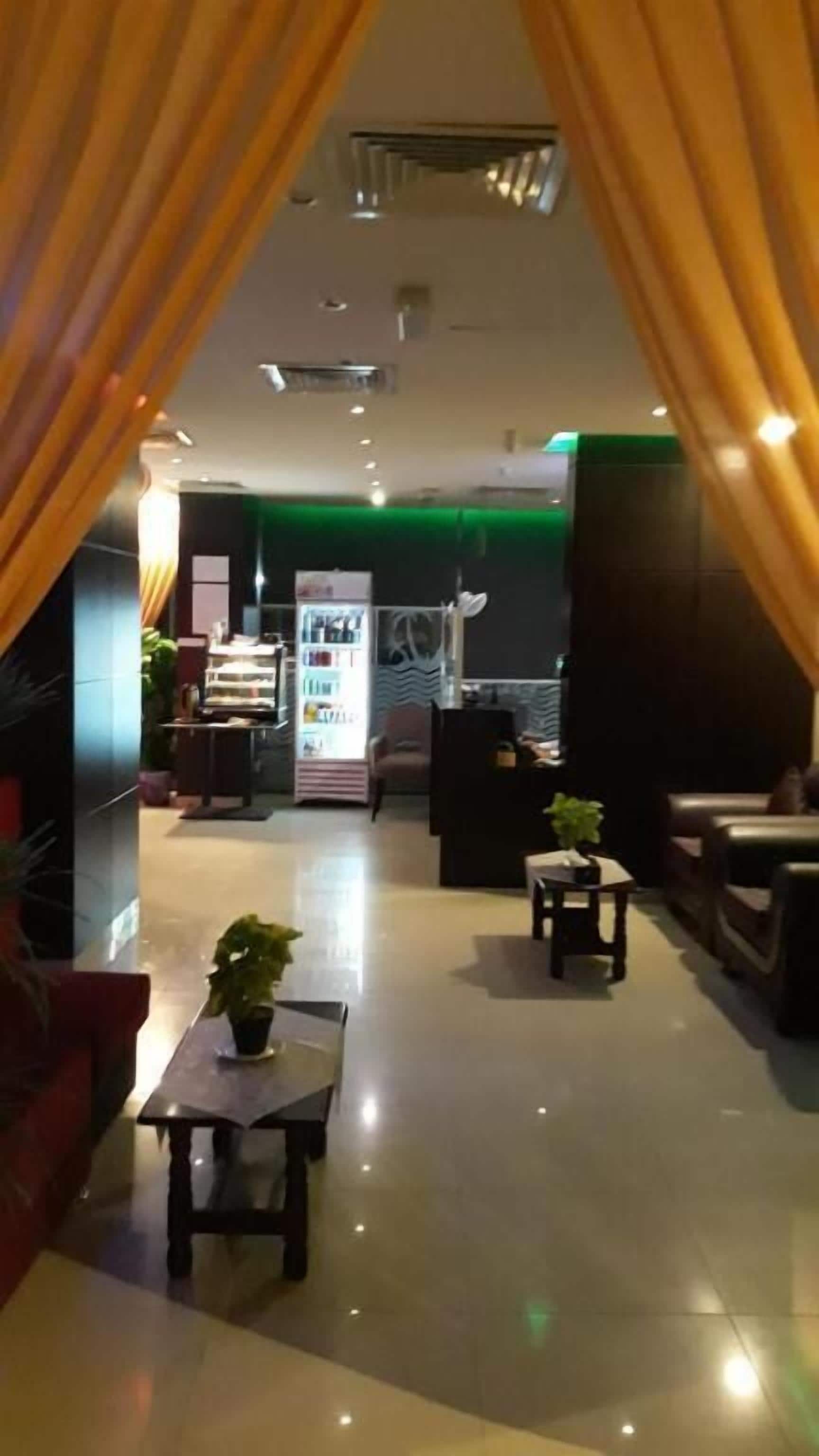 Un hall d’hôtel comprenant un comptoir d’accueil, un espace salon et un distributeur automatique.