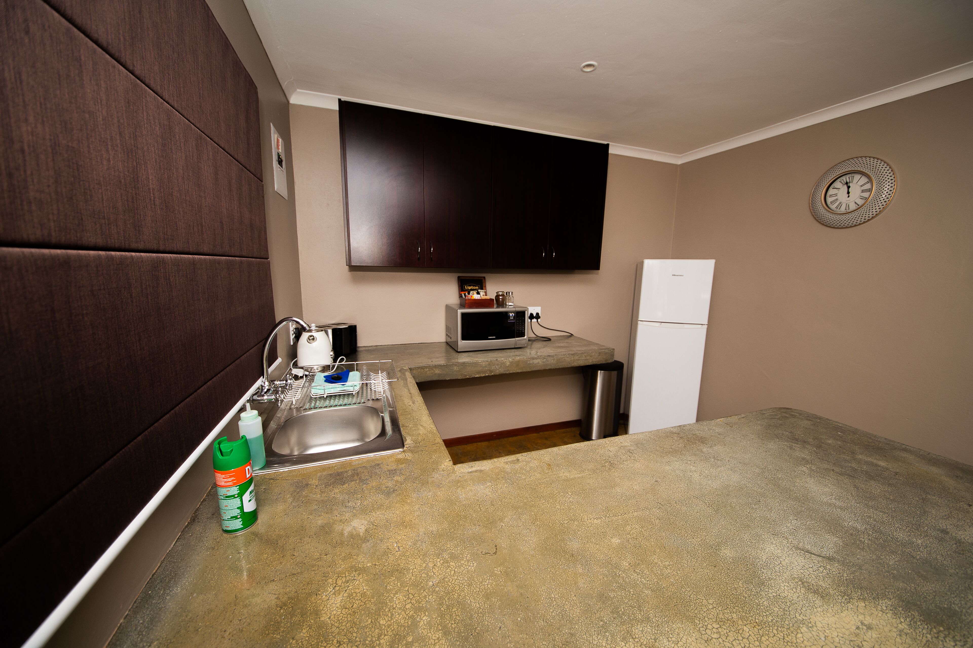 A compact kitchen with a microwave, a refrigerator, and a sink.