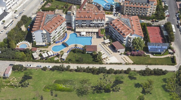 An aerial view of a hotel complex with multiple buildings, a central swimming pool, and surrounding greenery. - Monachus Hotel & Spa - All Inclusive (Manavgat)