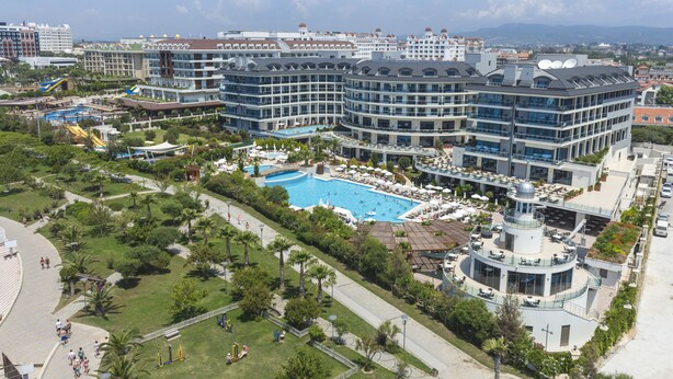 A hotel with a central swimming pool, multiple balconies, and a rooftop garden. - Commodore Elite Suites & Spa - All Inclusive - Adult Only (Manavgat)