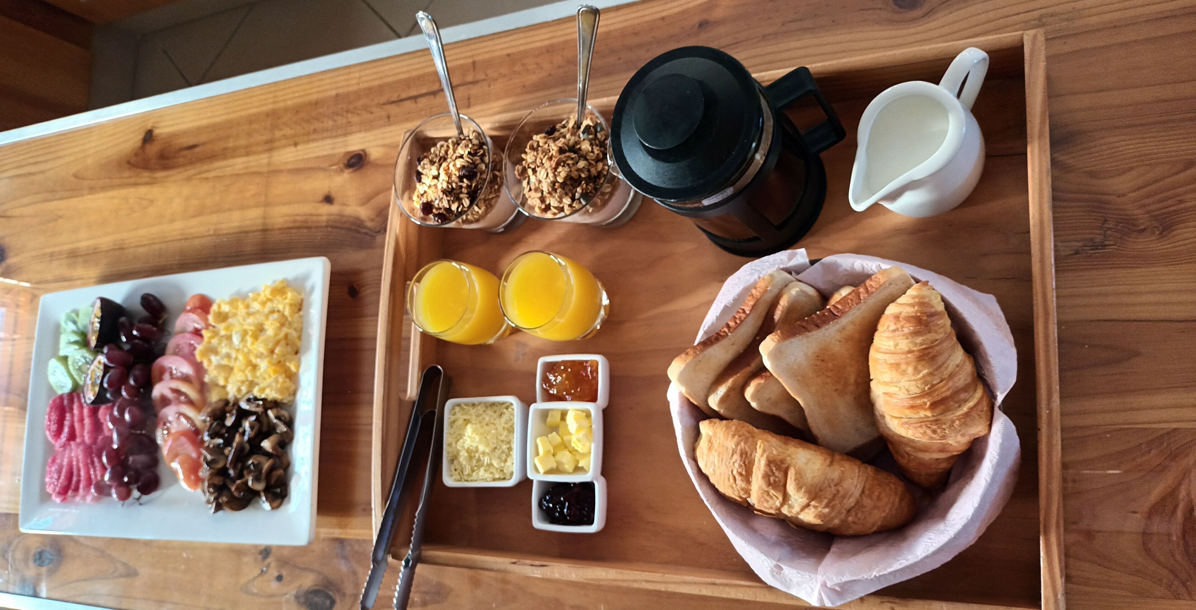A breakfast tray with various foods including eggs, toast, and pastries.