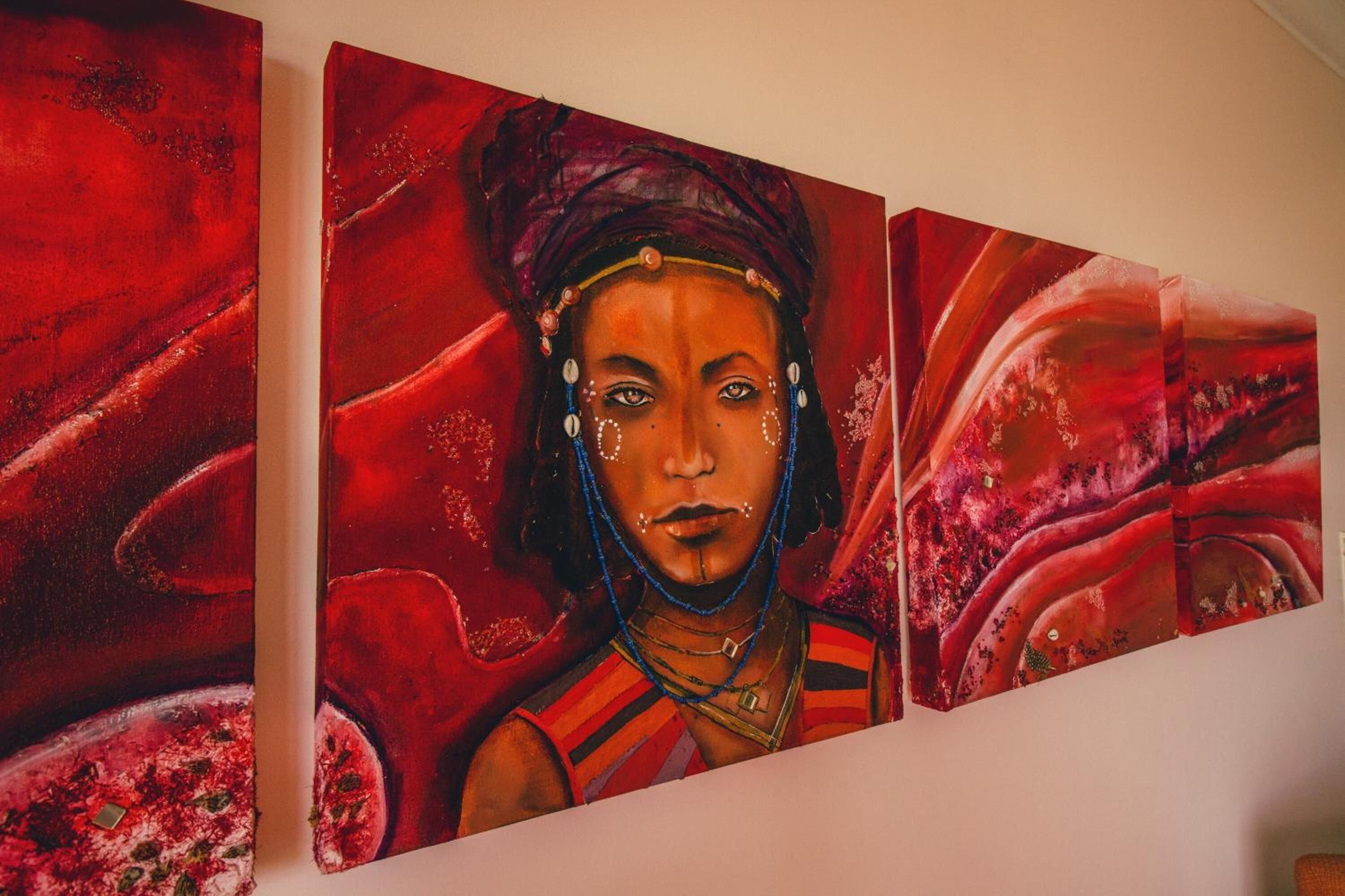 A triptych painting with a central figure and abstract red background.