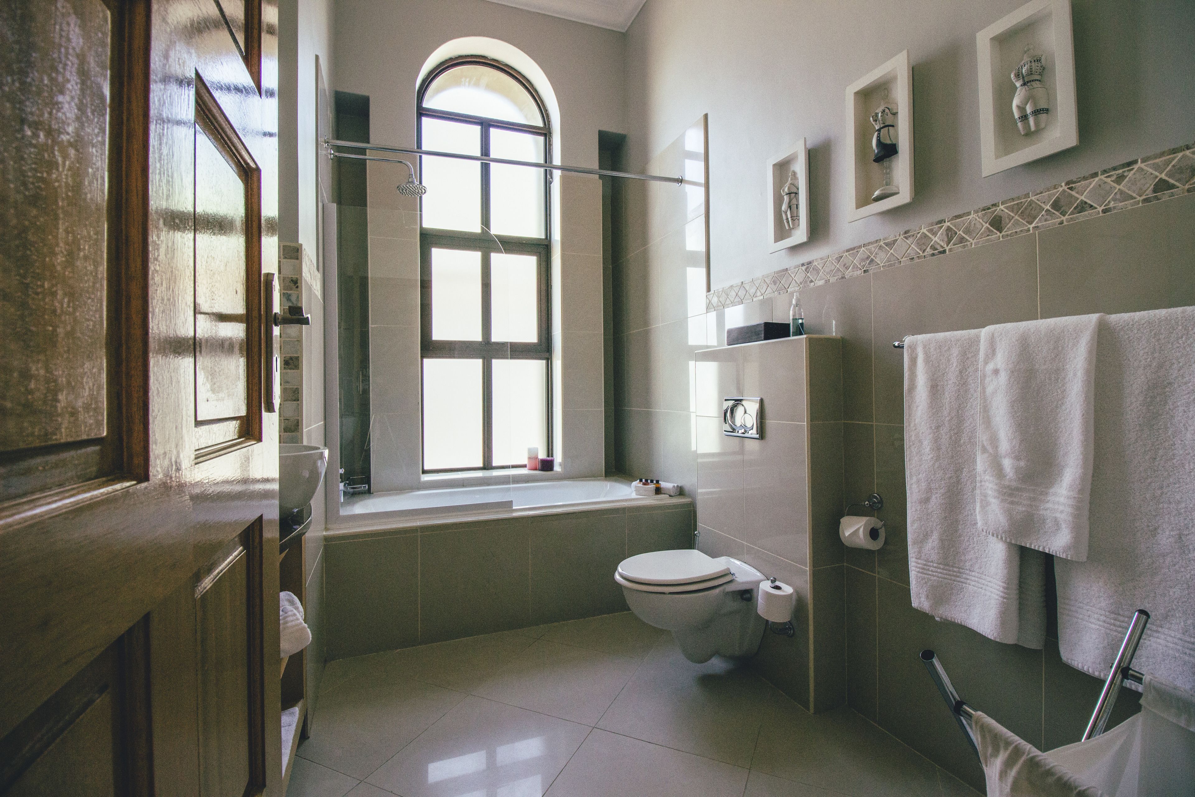 A bathroom with a bathtub, toilet, and a window.