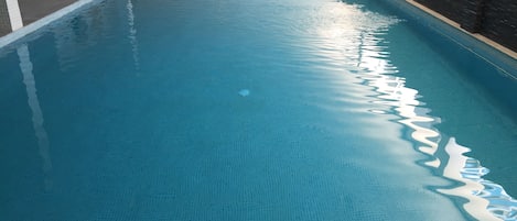 Una piscina techada, sillones reclinables de piscina