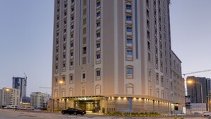 Un hotel alto y rectangular con techo plano y numerosas ventanas.