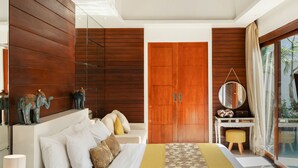 Een moderne slaapkamer met een groot bed, houten balkenplafond, een kledingkast en uitzicht op het omliggende landschap.