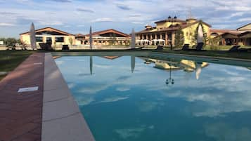 Una piscina al aire libre de temporada, sombrillas