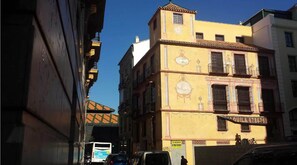 Un edificio amarillo con un letrero que dice 'SE ALQUILA 6786769'.