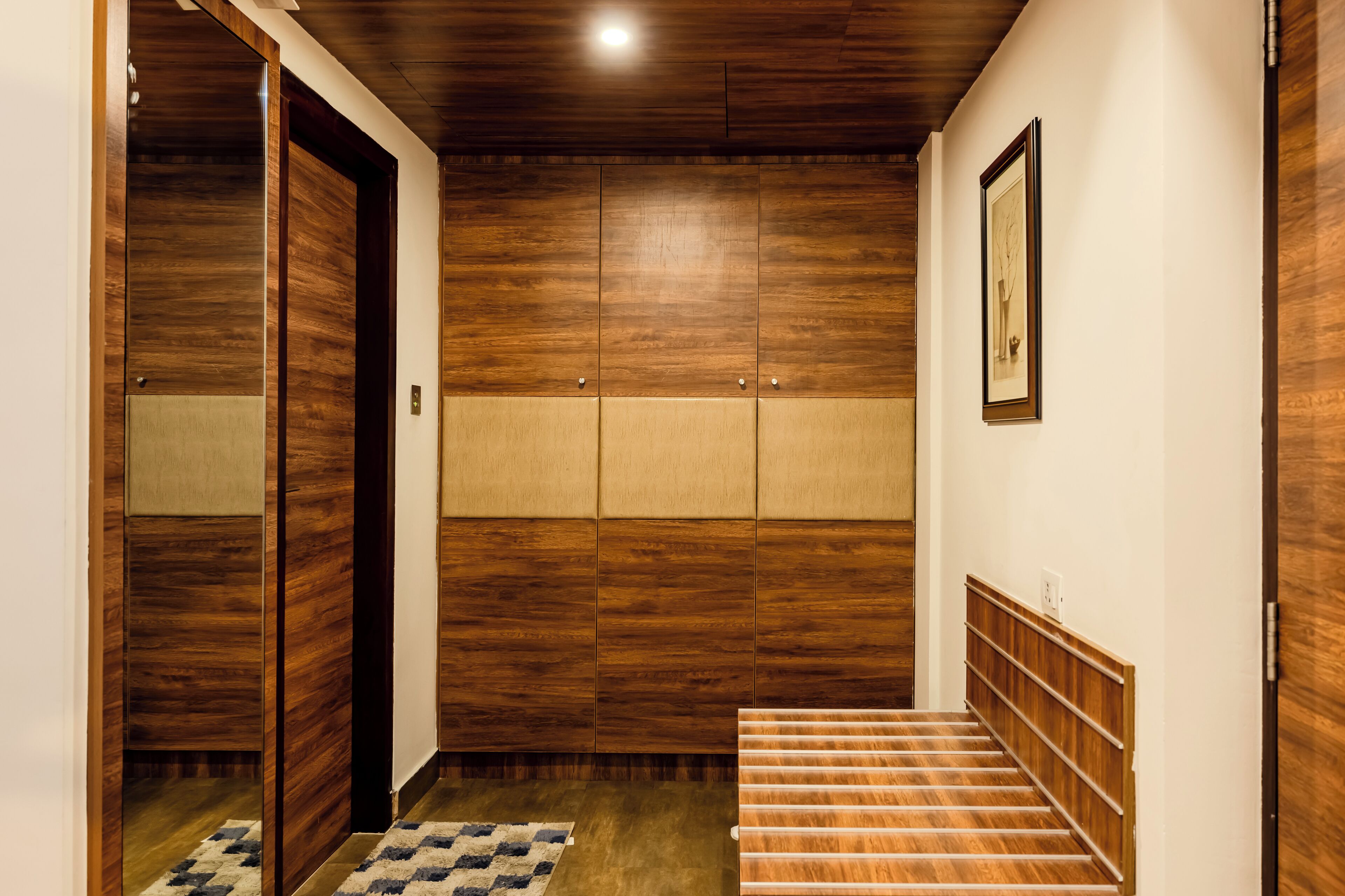 Ein Korridor mit Holzvertäfelung, einem gemusterten Teppich und einer Treppe mit Holzbeschlägen.