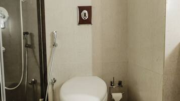 A modern bathroom with a toilet, bidet, and shower.