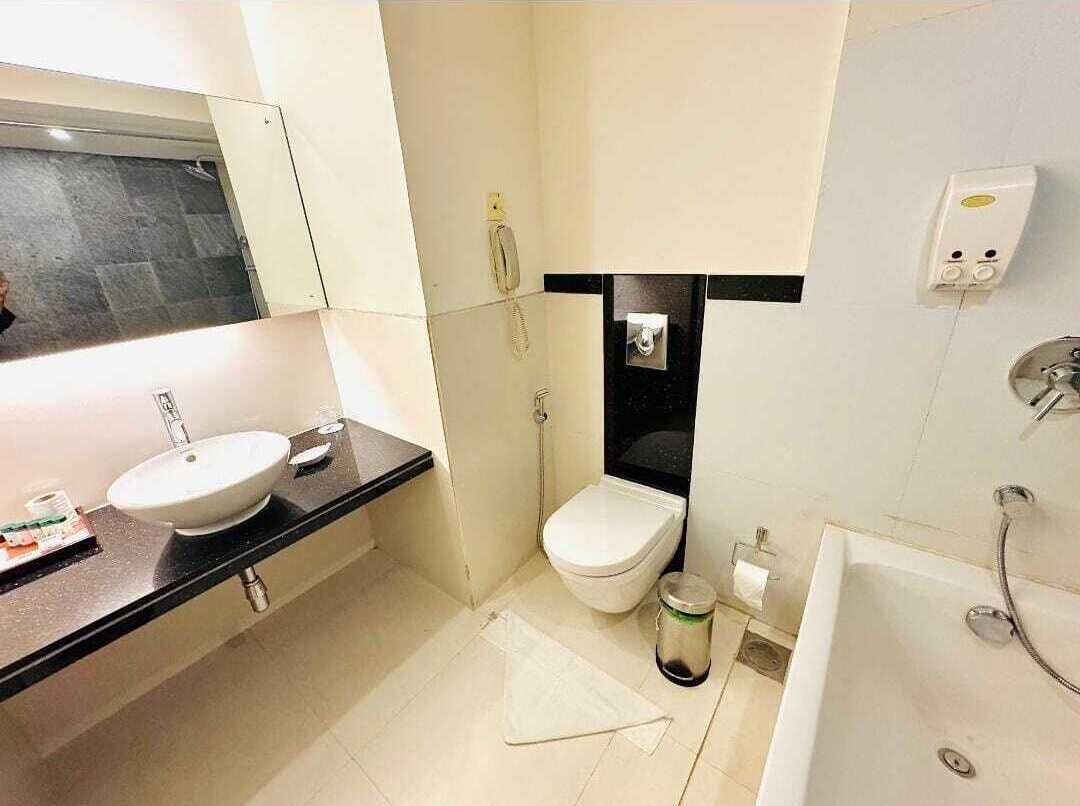 A modern bathroom with a sink, toilet, and bathtub.