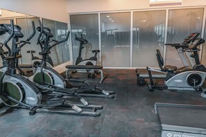 Un gimnasio con bicicletas estáticas, cintas de correr y máquinas de pesas.