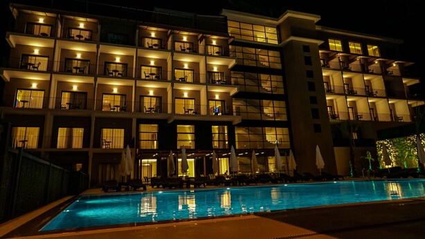 Un hôtel à plusieurs étages doté d’une piscine, de balcons et d’espaces de détente en plein air.