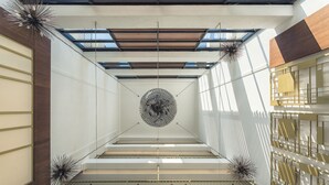 Un intérieur moderne avec un escalier central, des motifs géométriques sur les murs et un design de plafond original.