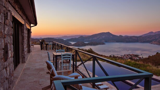 A terrace with outdoor seating overlooking a lake and mountains. - Kekik Otel Selimiye (Marmaris)