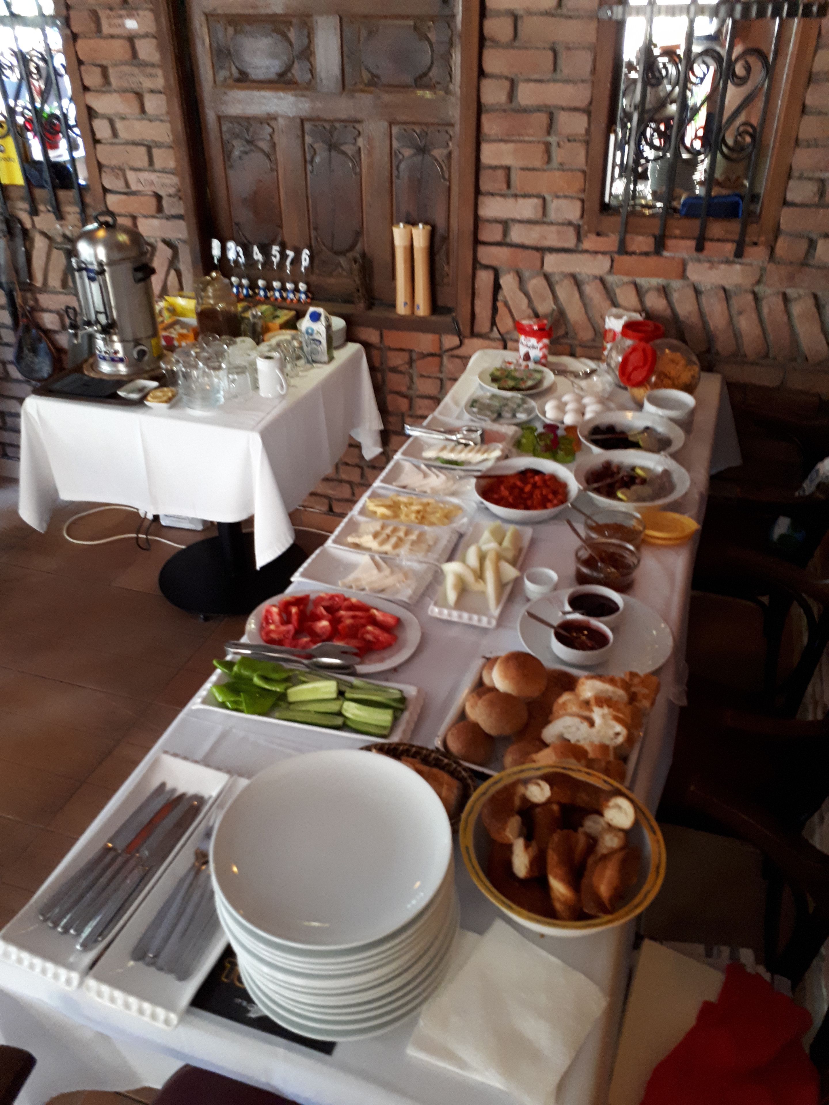 A buffet table with various food items and utensils.