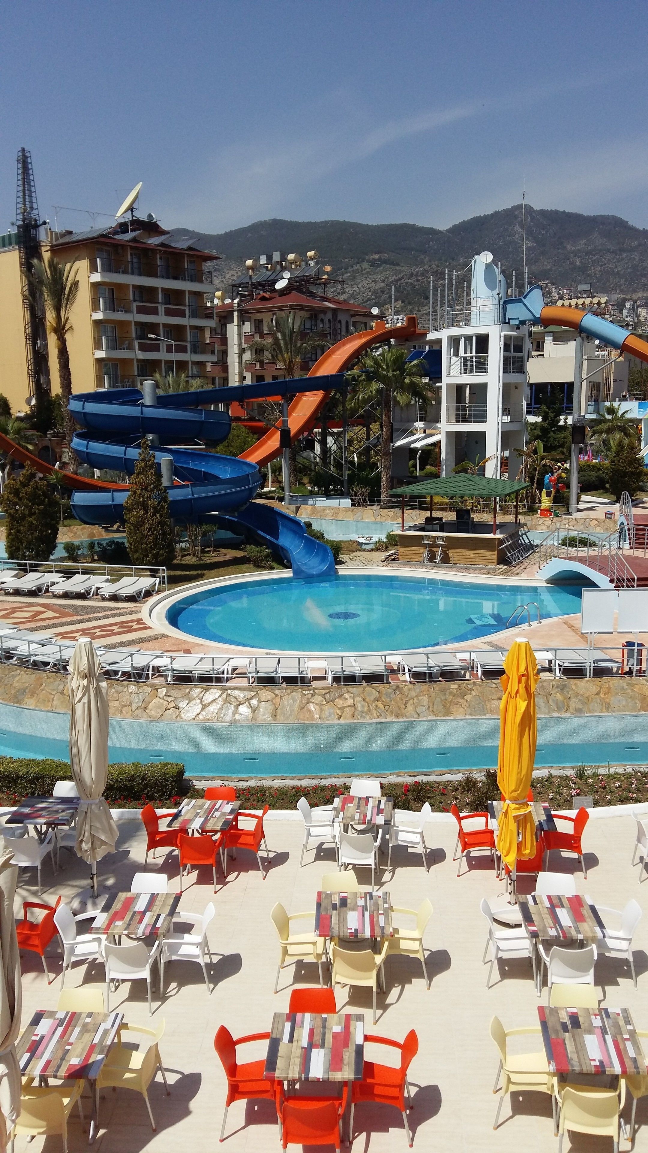 A resort with a pool, lounge area, and water slides.