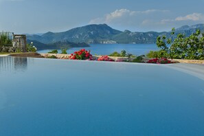 Una piscina con vistas a montañas y una masa de agua.
