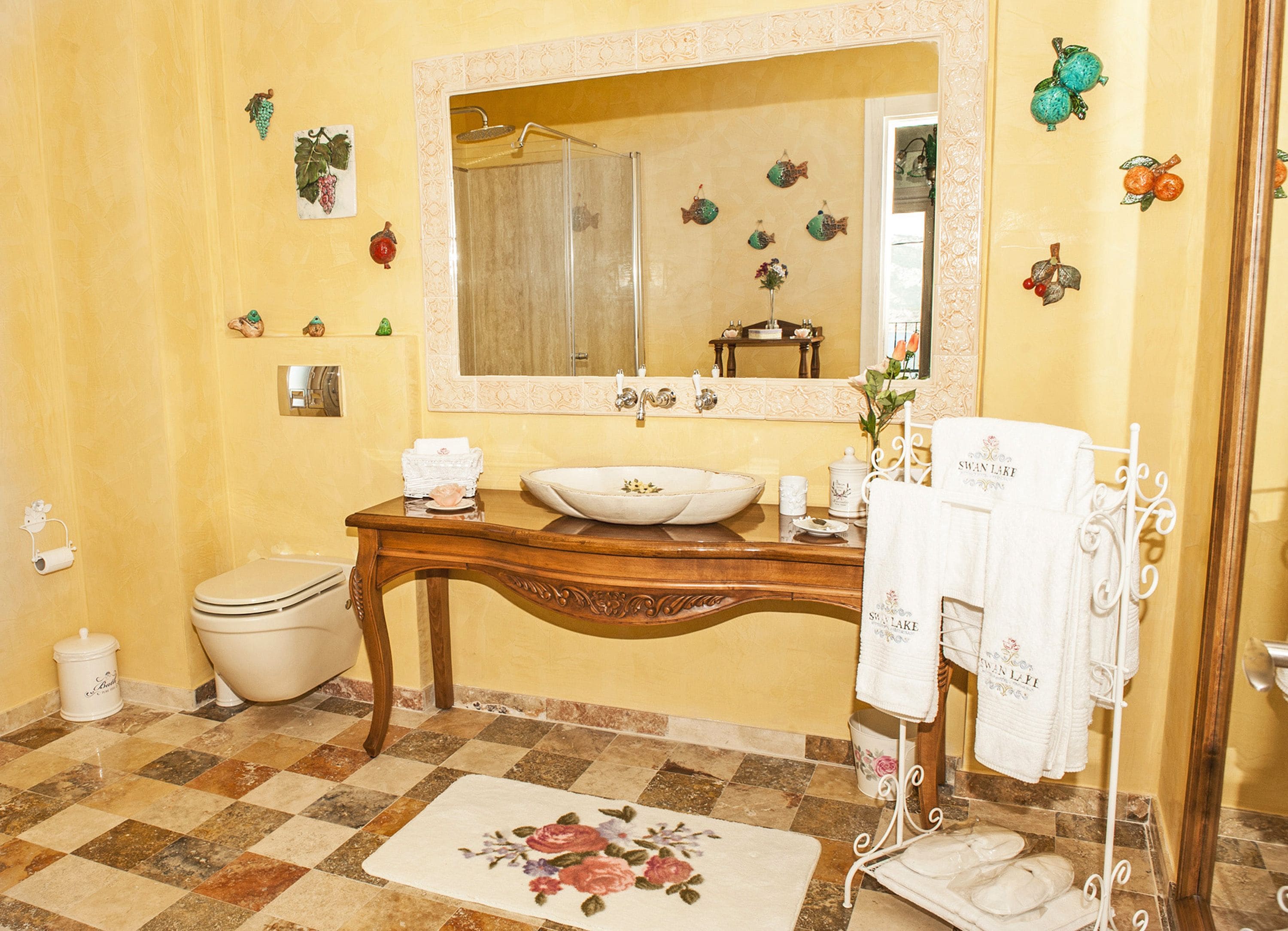 Een badkamer met een houten wastafelmeubel, een grote spiegel, een wastafel en een toilet.