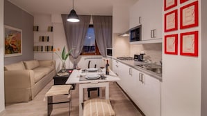 A compact living space with a sofa, dining table, and kitchenette. - Iron Bridge Accomodation (Rome)