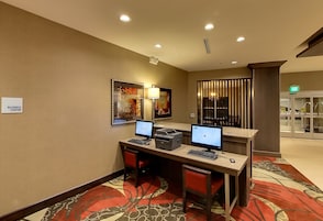 Espaço de negócios com duas estações de trabalho para computador, uma impressora e uma luminária.