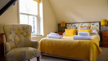 A bedroom with a bed, a chair, and a window.