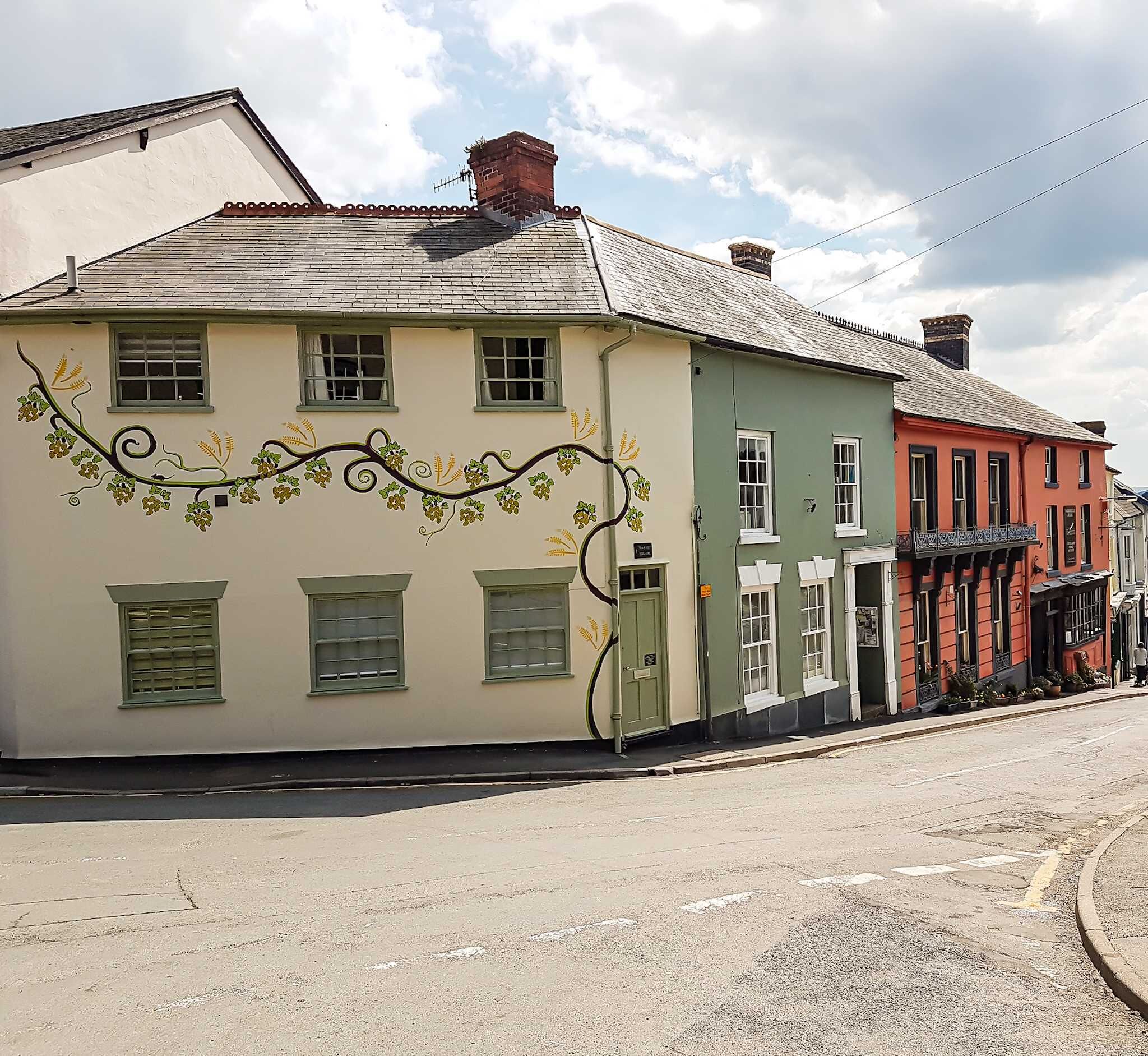 A row of colorful buildings with distinct architectural styles and a cobblestone street.