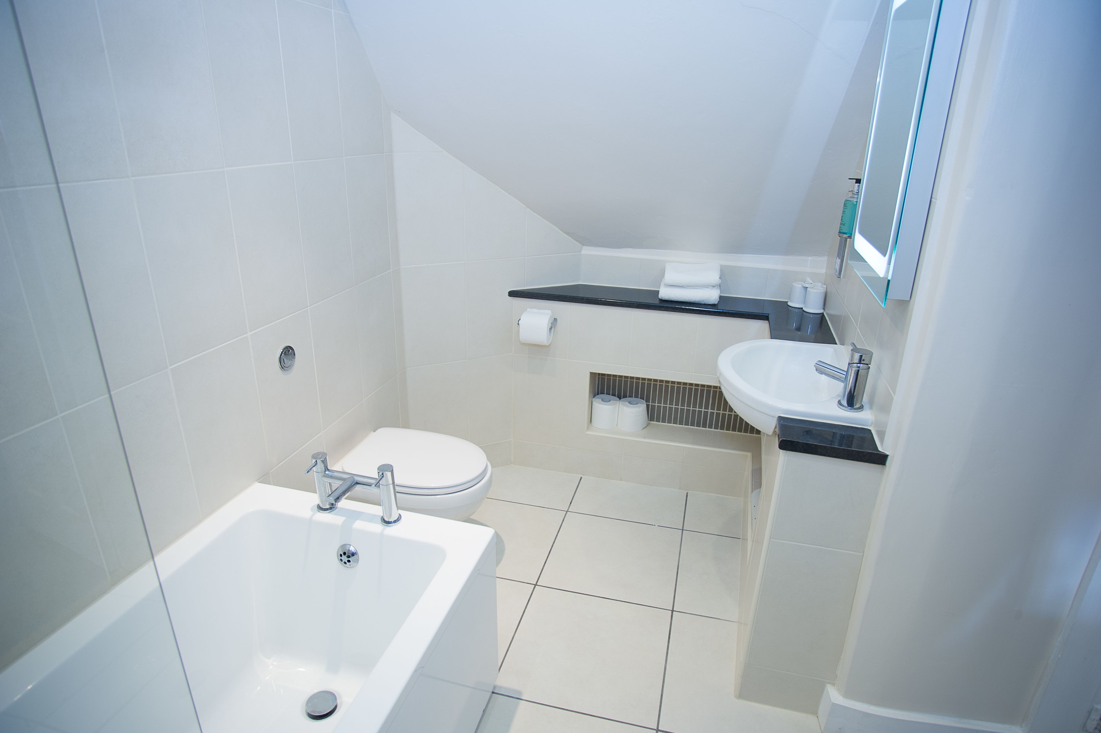 A modern bathroom with a bathtub, toilet, and sink.